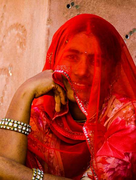 Rajasthani woman in red veil living in the mud houses of Pushkar, Rajasthan I Same day tour to Pushkar
