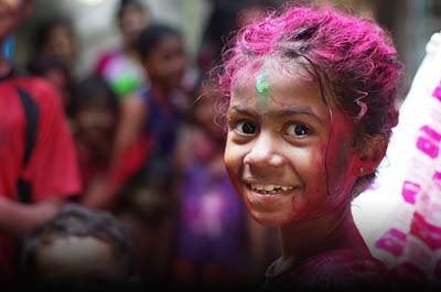 Foreign tourist splattered in vibrant colours of Holi in India. Indian holi Festival celebrations