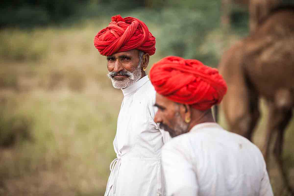 Traditional Rajasthani men wearing angrakha and bright coloured turbans, flaunting ethnic jewellery