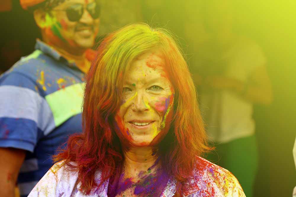 Foreign tourist enjoying holi Festival with vibrant colours in Mandawa, India.