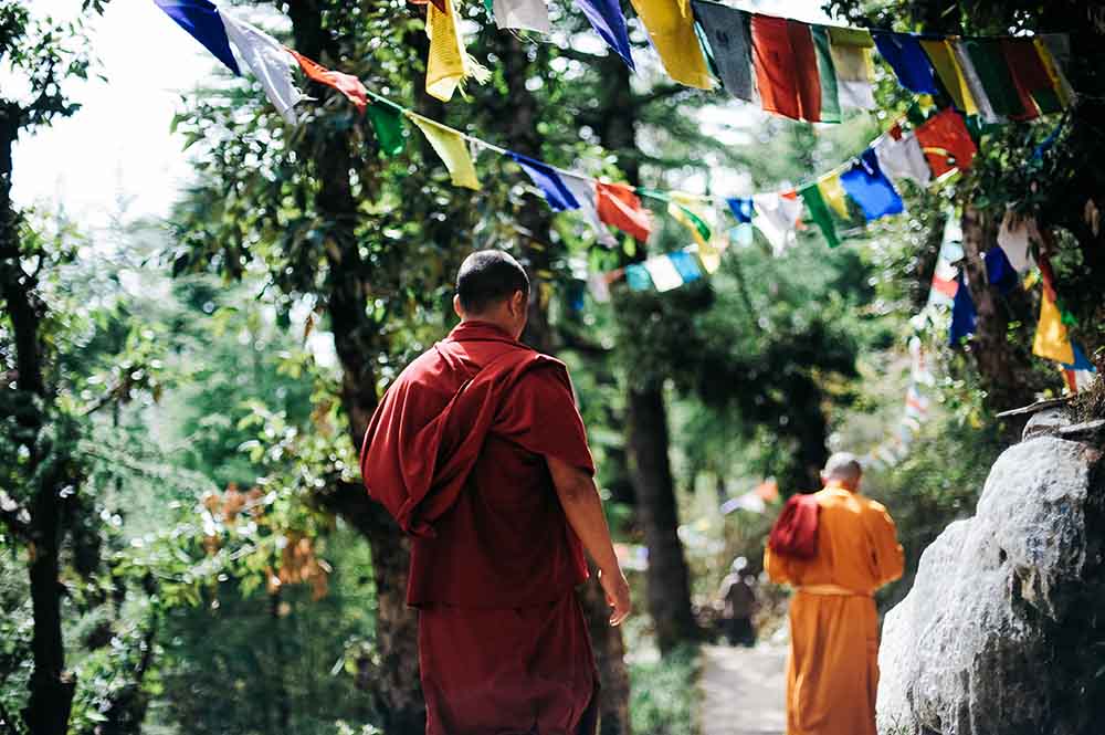 Buddhist Monks in maroon- red colored robes in the Himalayas of Leh & Ladakh I colourful Buddhist prayer flags